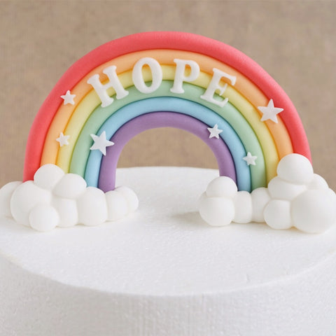 Pastel fondant rainbow cake topper with clouds and name
