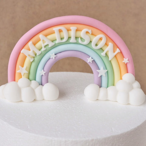 Pastel pink fondant rainbow cake topper with clouds and name
